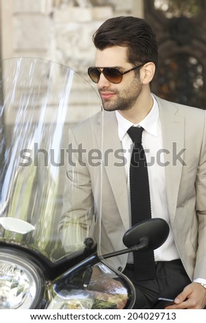 Portrait of young modern businessman with scooter.