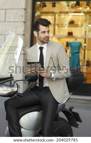 Portrait of young modern businessman with scooter.