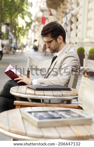 Modern businessman sitting at coffee shop and making financial plan. Small business.