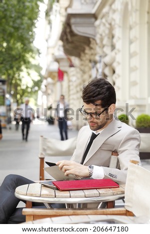 Modern businessman sitting at coffee shop and making financial plan. Small business.