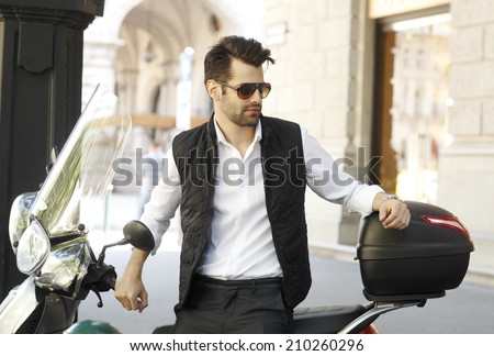 Portrait of modern businessman sitting on scooter at the city. Business people.