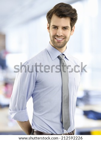 Portrait of young businessman standing at office. Small business.