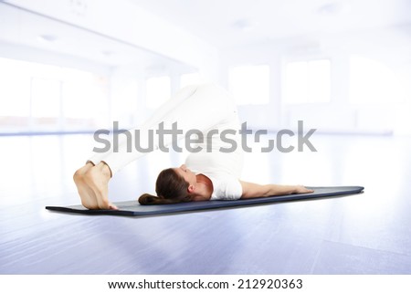 Yoga instructor doing exercise on yoga mat in studio.