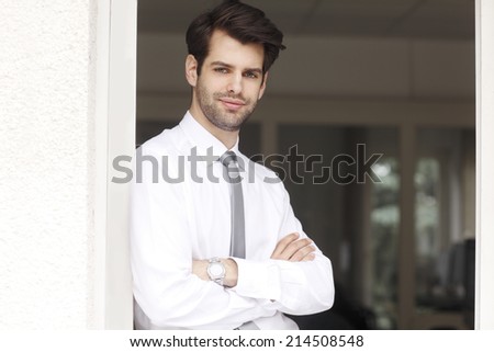 Portrait of executive young financial businessman standing at office. Business people.