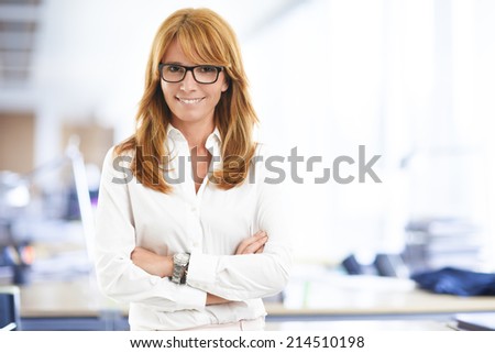 Close-up portrait of executive business woman standing at office. Business people.