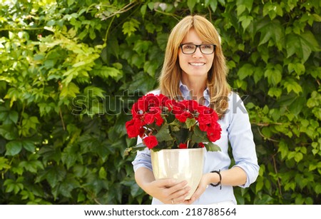 Portrait of online flower shop owner, with potted flower. Small business.