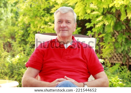 Active casual businessman sitting at home at garden.