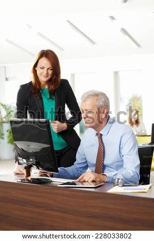 Old sales man discussing with business woman, while working on laptop. Business people.