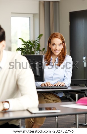 Portrait of middle age business woman working on laptop while sitting at office.