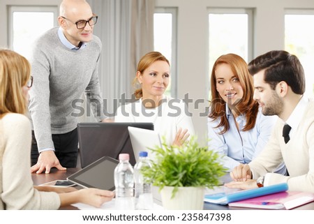 Group of business people with laptop working on business project while sitting at meeting.