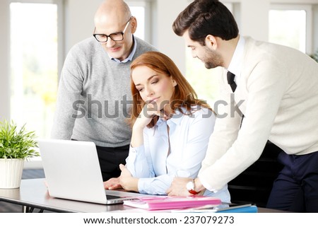 Sales team working with laptop while sitting at meeting.