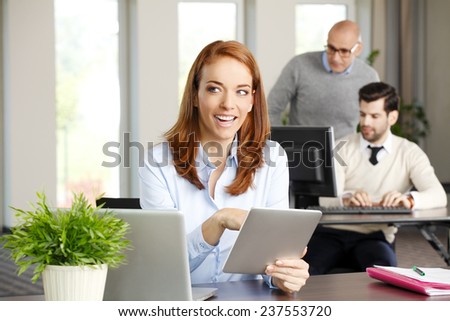 Close-up portrait of executive business woman holding digital tablet while working on project at office. Business meeting.