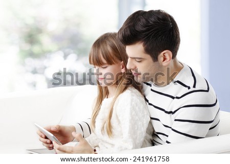 Young father studying his little daughter how to use internet safety at home.