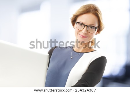 Portrait of executive sales woman working on laptop white sitting at office.