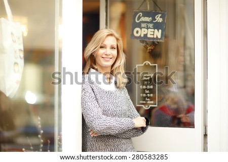 Portrait of designer woman standing in front of small vintage store. Small business.