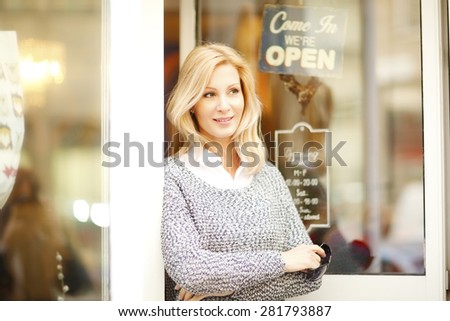 Small business. Portrait of attractive female owner standing with arms crossed at shop facade.