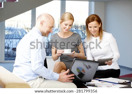 Portrait of senior businessman presenting his idea to his sales team. Businesswomen drinking coffee and holding digital tablet. Teamwork at office.
