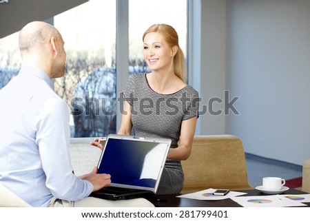Business consultation. Businesswoman and businessman sitting at office and using computer and digital tablet.