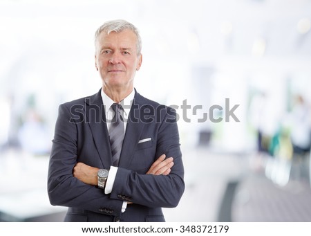 Portrait of executive financial director standing at office with arms crossed while looking at camera.