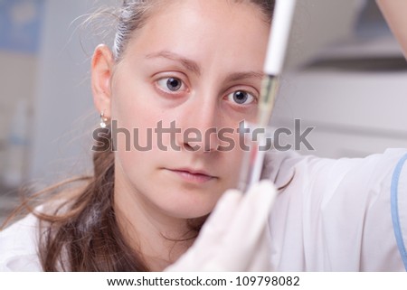 Woman dropping blood simple with micro pipette in test container