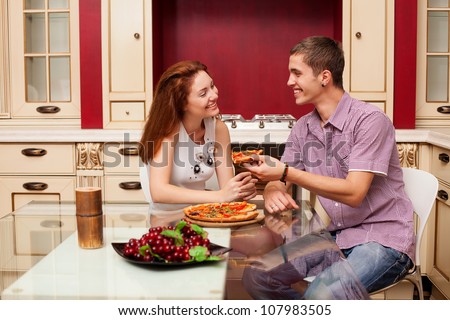 a young couple in love eating pizza