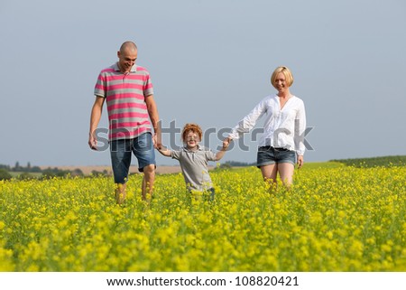 happy family having fun in the field with yellow flowers. outdoor shot