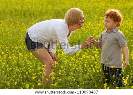 Mother and Son Having Fun. Mom giving flower to her son. outdoor shot.