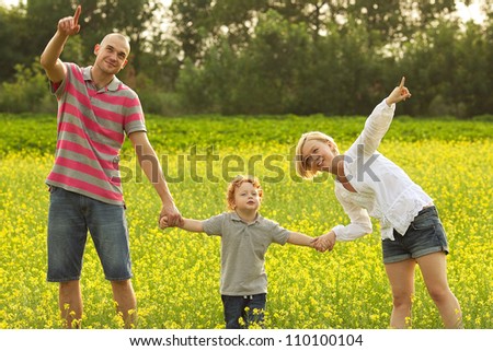 happy family having fun in the field with yellow flowers and watching up in the sky. outdoor shot