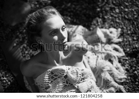 fashion model laying on the ground in shawl,black and white outdoor shot