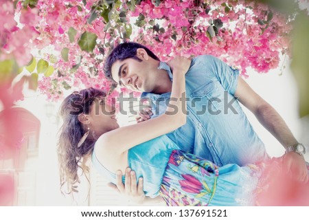 young couple in love cuddling in a lush garden and a whirl in the dance