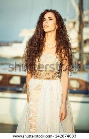 fashion model in lace dress outside posing ,yahts on background