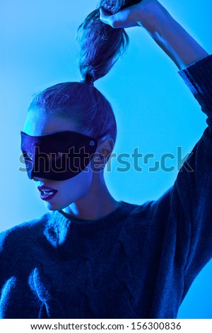fashion woman posing in mask, art photo with blue light