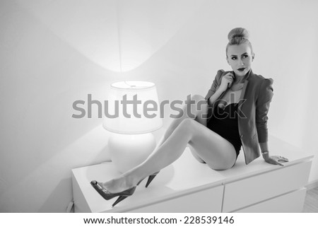 fashion woman sitting close to the lamp, unusual ligh effect, black and white