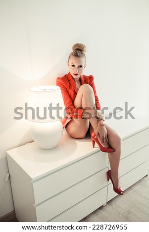 fashion woman sitting close to the lamp, unusual light effect