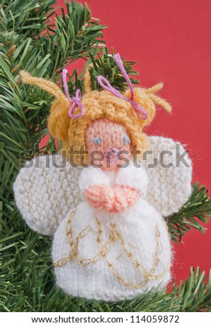 Christmas angel decoration knitted. Home made knitted angel hanging on a Christmas tree. Old fashion and home made ornaments for Christmas concept.