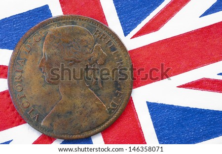 One penny copper coin with an image of queen Victoria from 1864 on a British flag background. This coin has been in circulation. Concept representing British Empire or old coin collecting.
