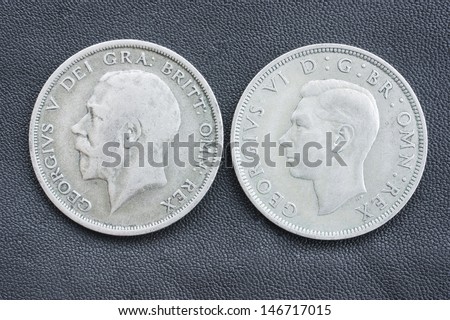 Obverse side of  two half crown British coins, of king George V (from 1920) and his son George VI (from 1946). George VI was the father of Elizabeth II, the queen of England .