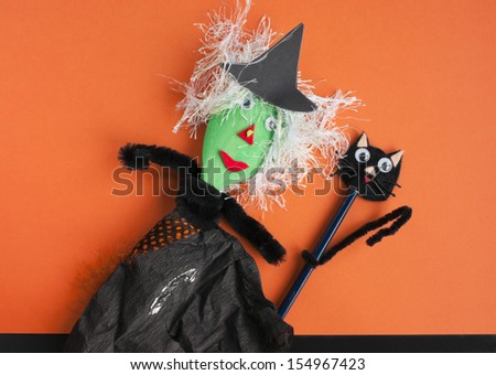Halloween toys. Witch made of a wooden spoon, tissue paper and pipe cleaners and a cat made of an old pencil and pipe cleaners. Concept for Halloween craft and fun with children.