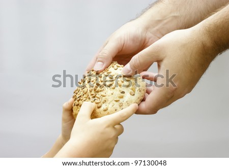 Sharing bread. Man giving bread to a small child. Charity concept.