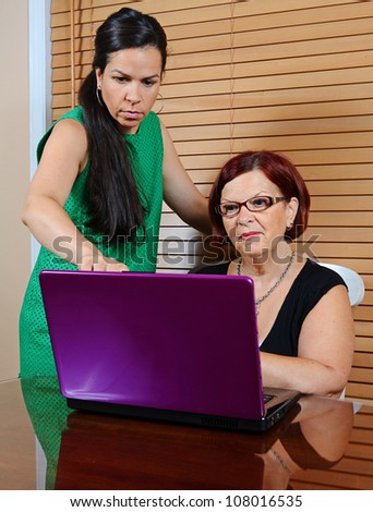 Image of a young lady using a laptop with an older lady