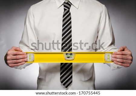 Man with tie holding a level
