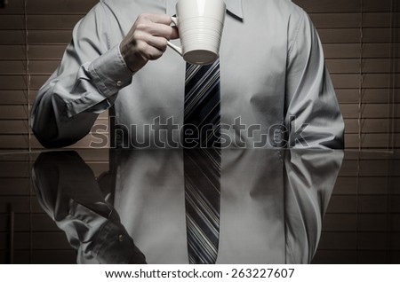 Man with shirt and tie about to drink