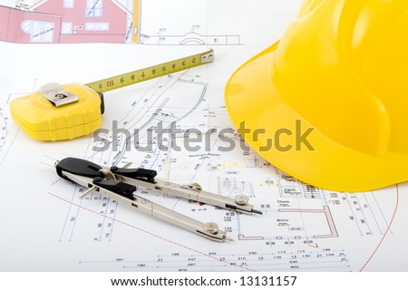Building plan with safety helmet, pair of compasses and rolling meter