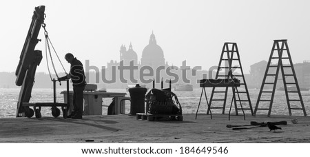 VENICE, ITALY - MARCH 14, 2014: Repair on the waterfront and silhouette of Santa Maria della Salute church.
