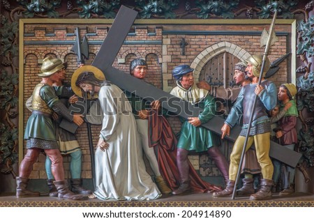BRUGES, BELGIUM - JUNE 13, 2014:  Simon of Cyrene help Jesus to carry his cross. Relief in st. Giles church (Sint Gilliskerk) as part of the Passion of Christ cycle.