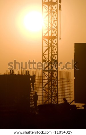 building in the sunset and workers