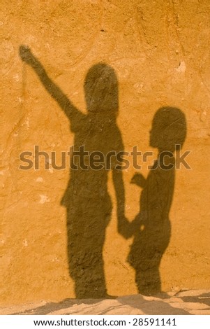 shadow of sisters on the sand wall
