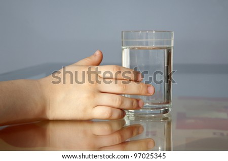 hand of child and glass of water