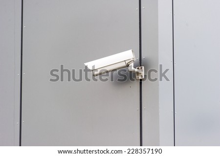 A picture of a security camera on a modern building.
