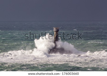 Huge waves crashing Longships Lighthouse photographed from Lands End Cornwall England UK